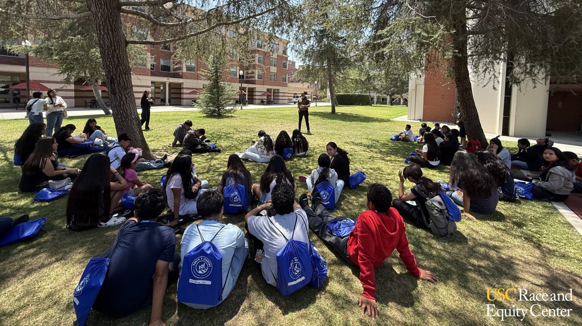 People sitting on lawn at college campus